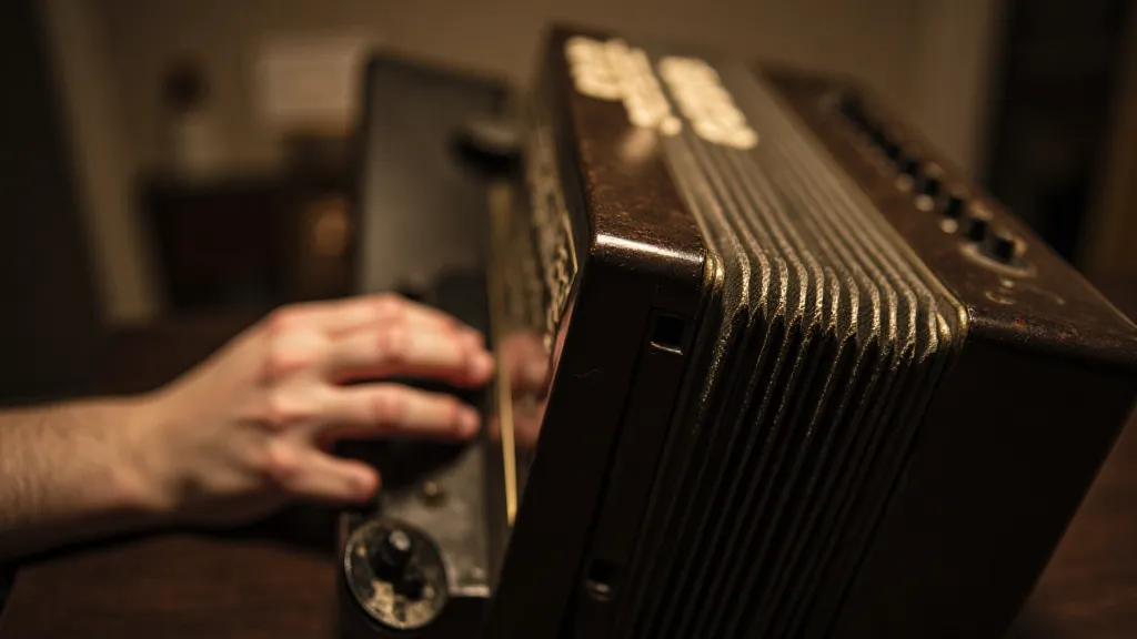 Close-up of an antique accordion with a hand pressing a button